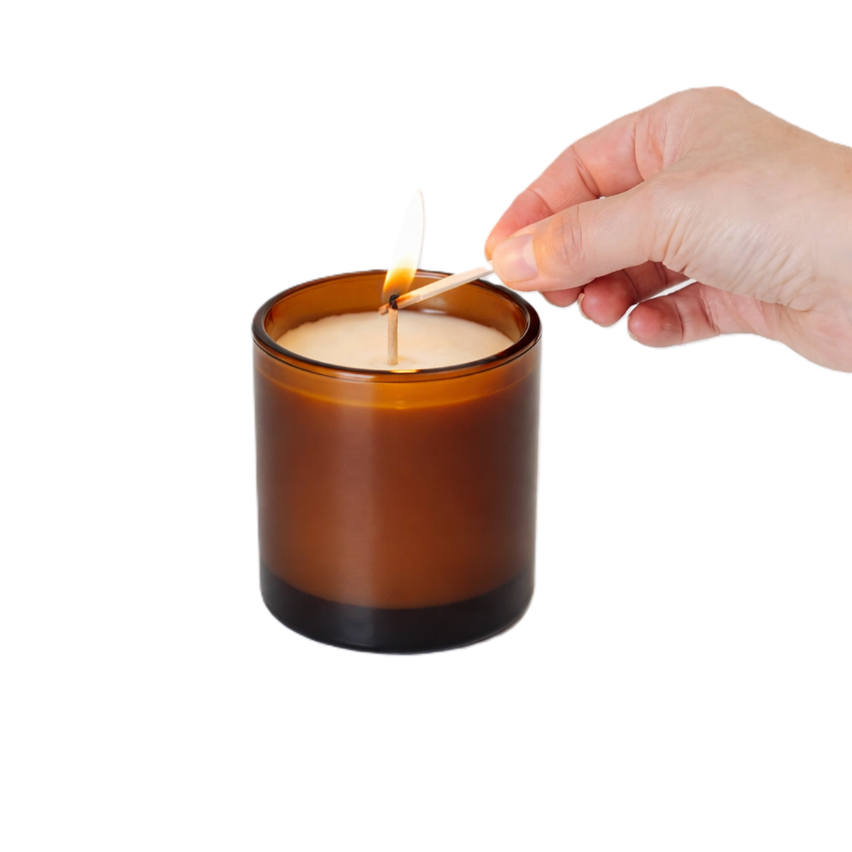 Hand lifting the lid from a lit amber candle