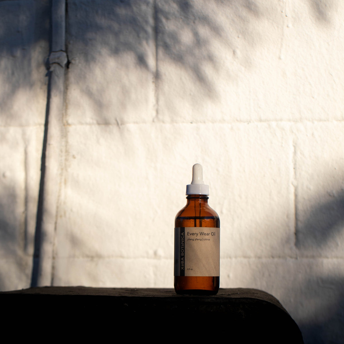 Amber bottle on a ledge against white stucco wall